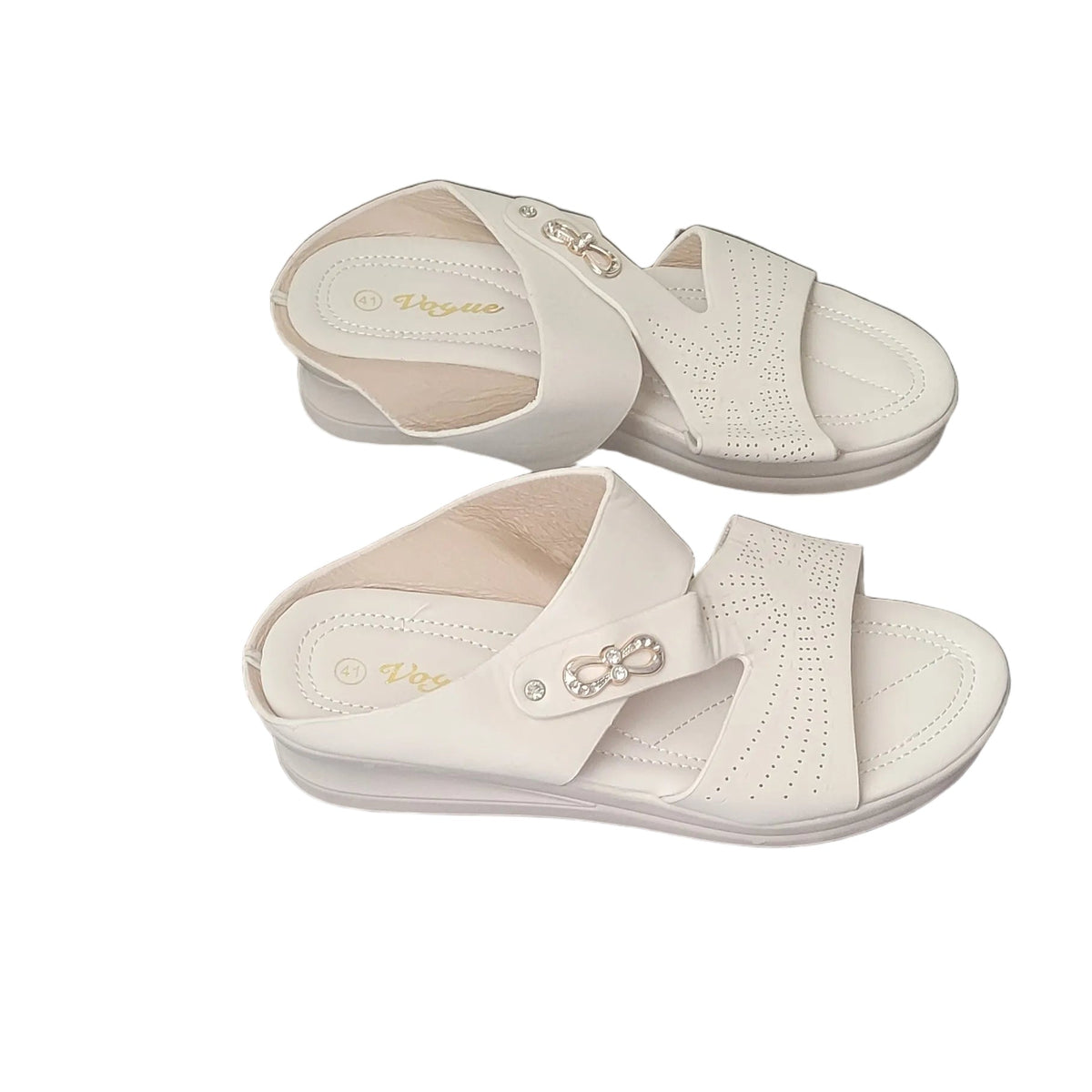 A pair of off-white platform slide sandals with double straps and small rhinestone embellishments, resting on a dark wood floor.