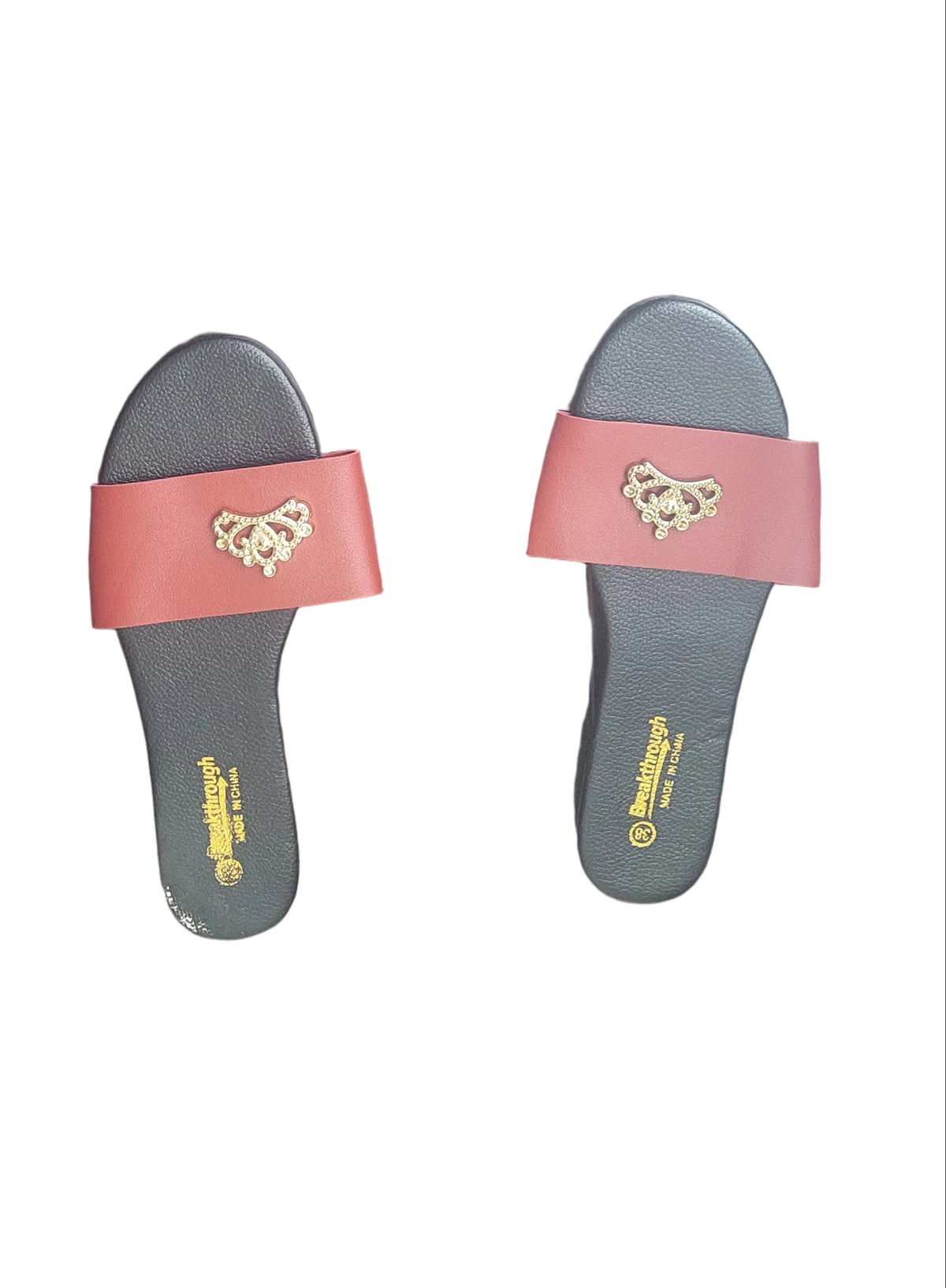 A pair of black insoles with red straps and a gold lion emblem, displayed on a dark wood floor.