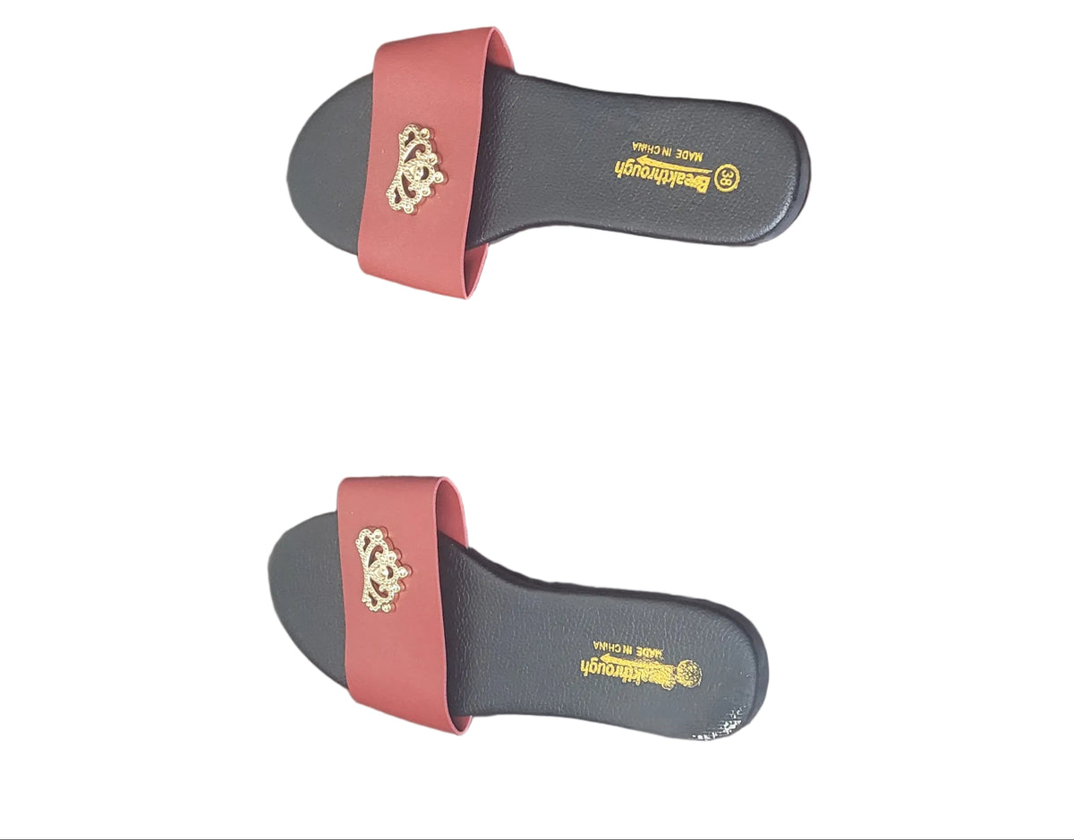 A pair of red slide sandals with gold logos, placed on a dark wood floor. The brand name 'Majestic' is visible on the soles.