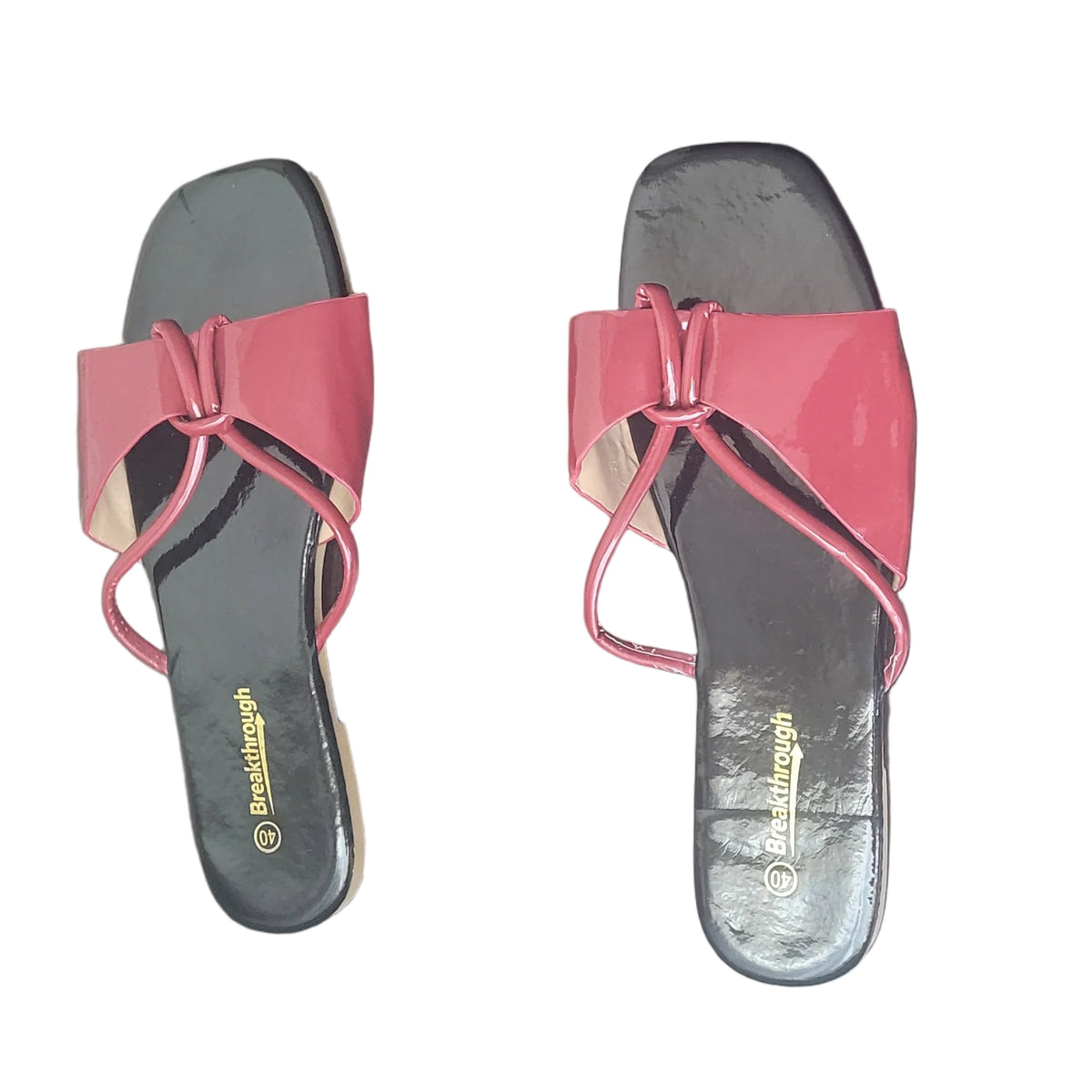 A pair of red and black slide sandals with bow details on the straps, placed on a dark wood floor. The brand name 'SABINE' is visible in gold on the insole.