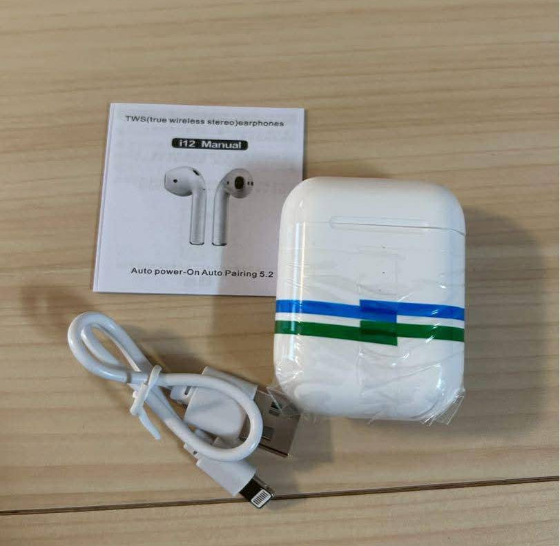 White wireless earbuds charging case with blue and green stripes, shown with a white USB cable and a product card on a light wood surface.