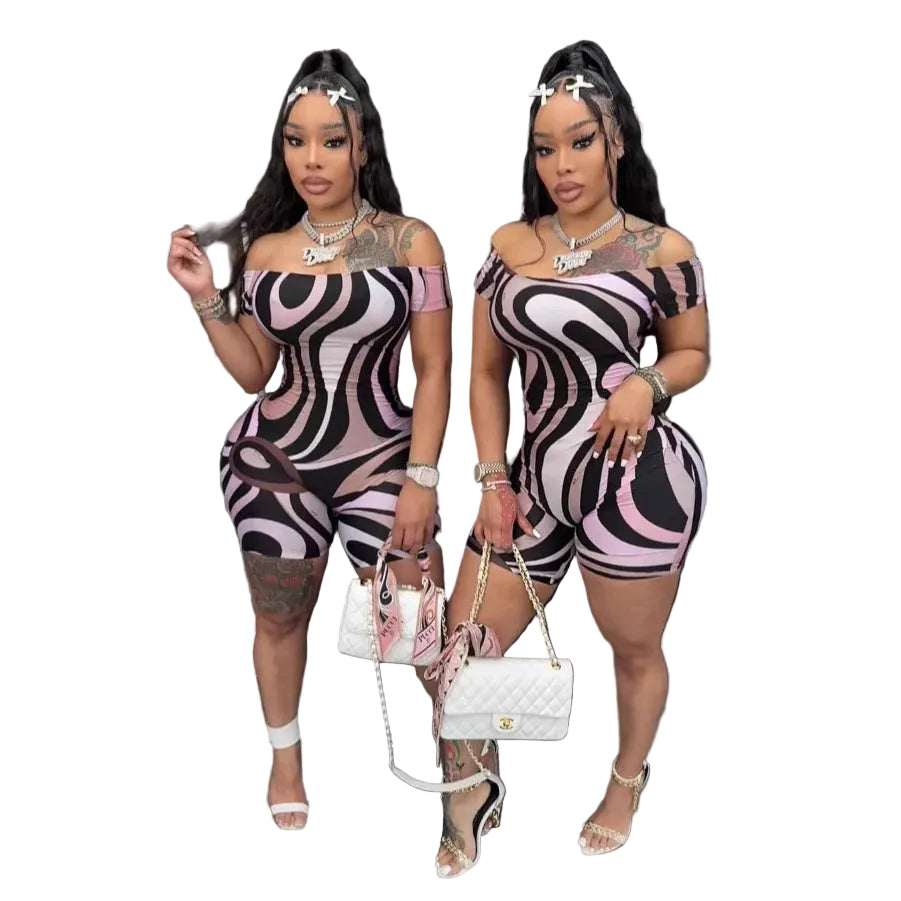 Two women in matching patterned outfits posing indoors.