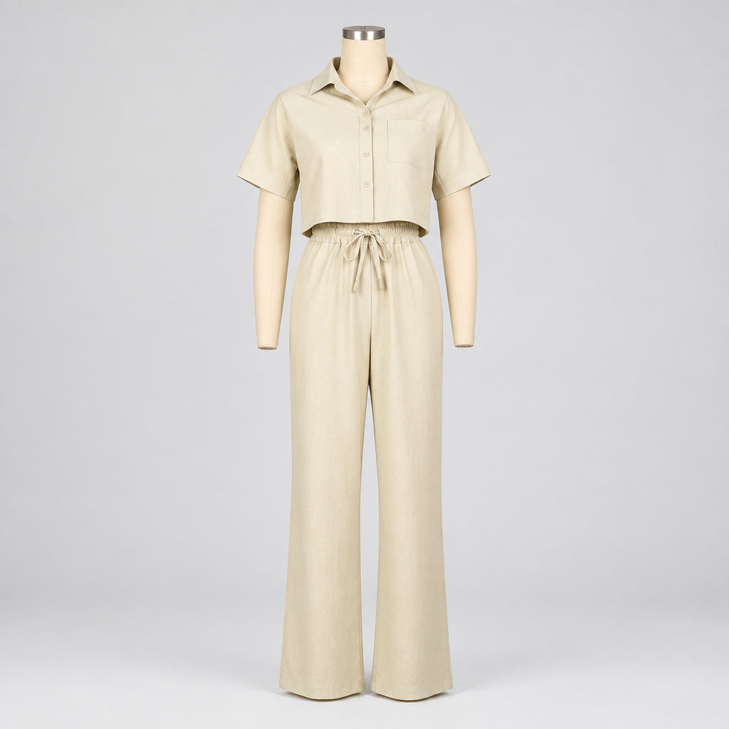 A short-sleeve collared button-front top and matching wide-leg pants set in a light cream or beige color, displayed on a mannequin against a plain white background. The brand name 'CM.