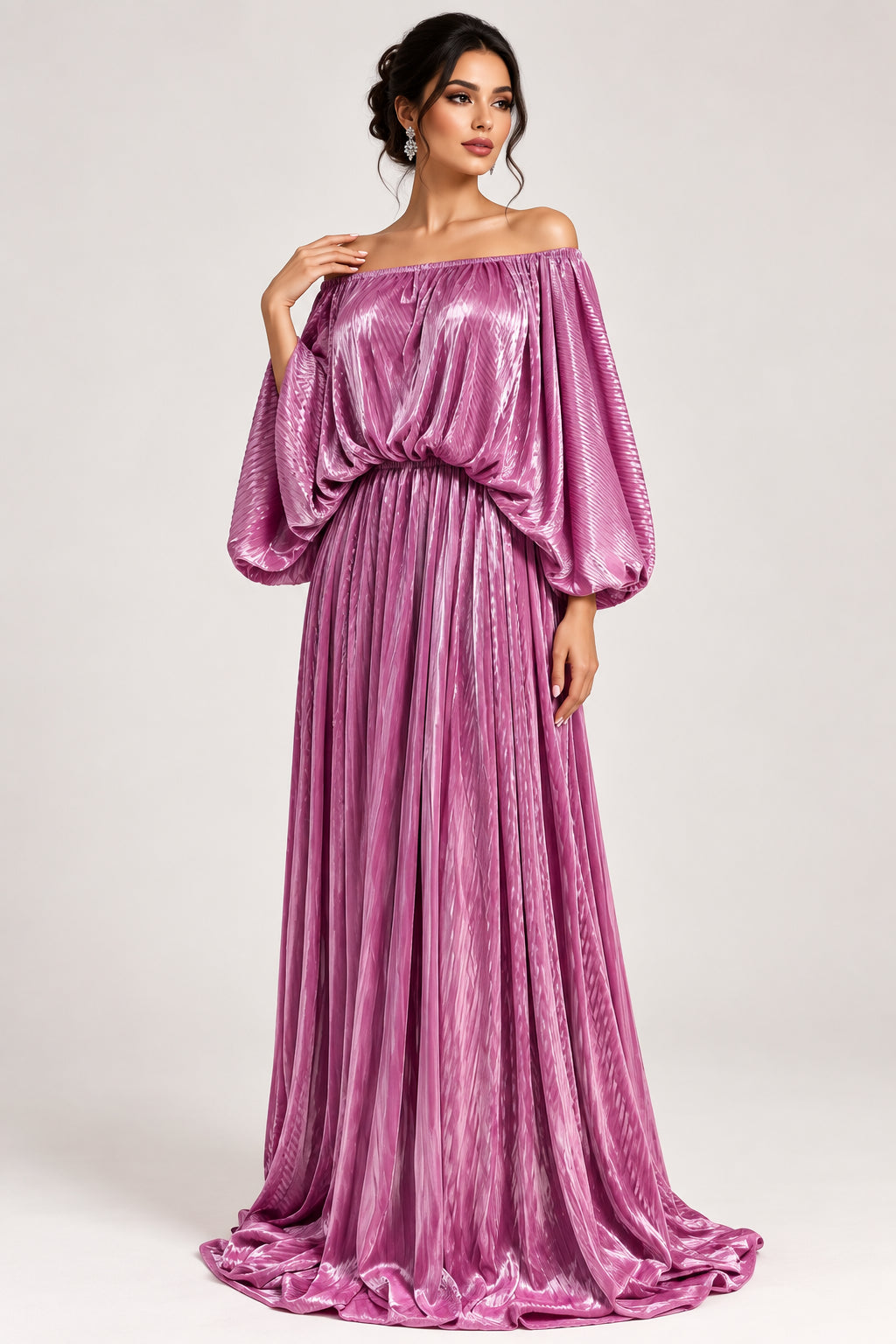 A floor-length magenta-purple velvet gown with wide draped sleeves and a gathered waist, displayed on a mannequin in an indoor room with a potted plant and paneled wall.