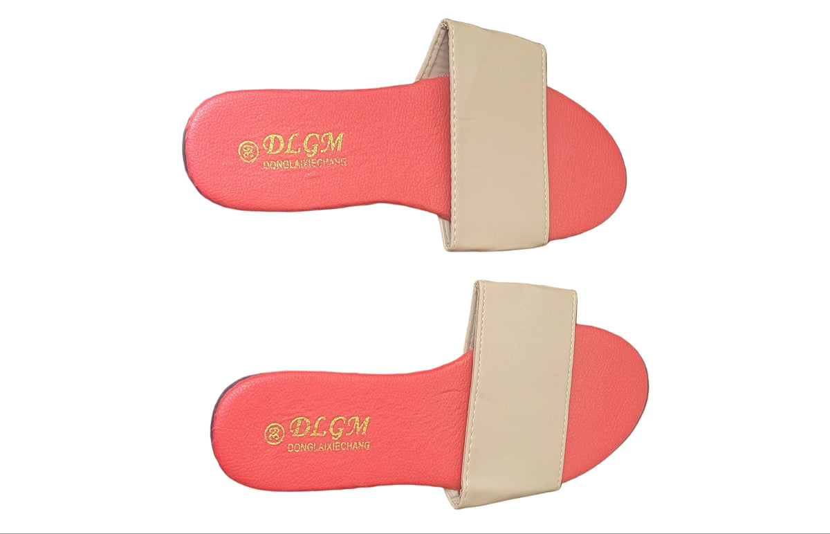 A pair of coral red slide sandals with beige straps, displayed on a dark wood floor. The brand name 'BLOOM' is printed in gold on the footbed.