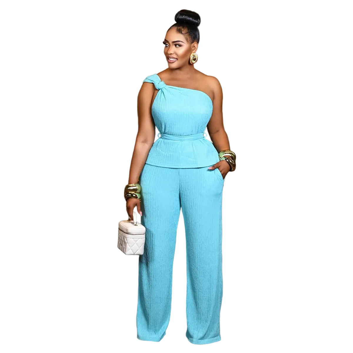 A woman models a light blue one-shoulder jumpsuit in a modern living room setting. The jumpsuit features a peplum waist and wide-leg pants.