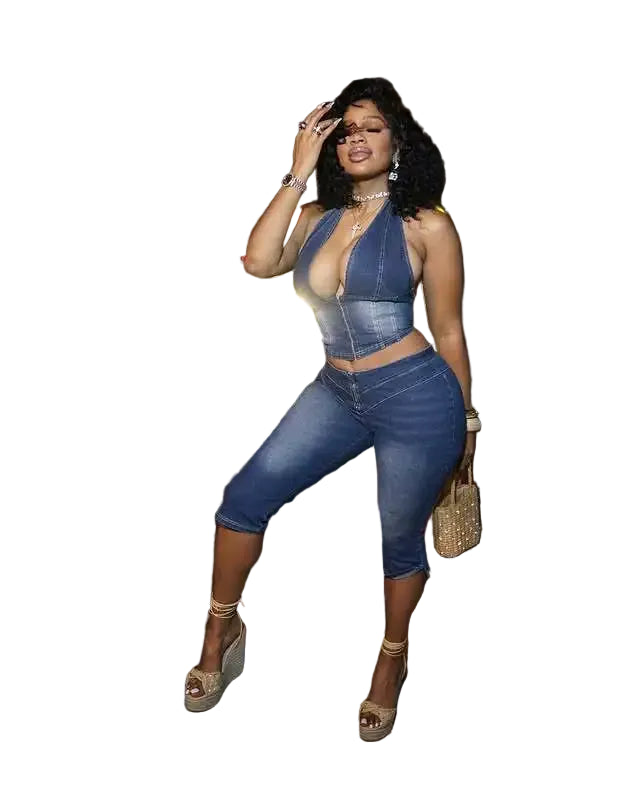 Woman in a denim outfit posing outdoors at night.