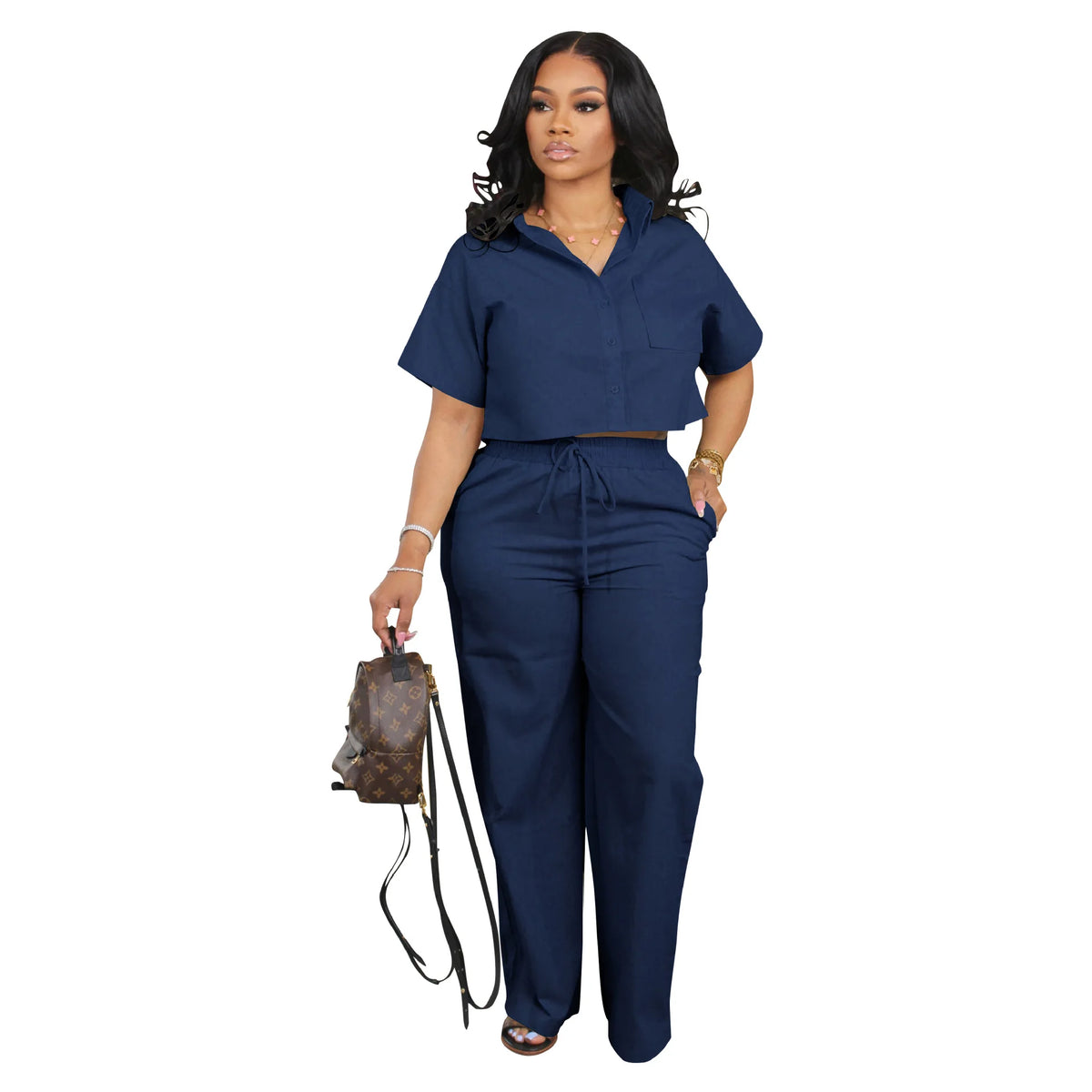 Woman wearing a navy blue outfit with a backpack on a white background